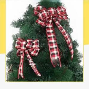 Close-up of red and black plaid Christmas bows hanging on a festive pine tree