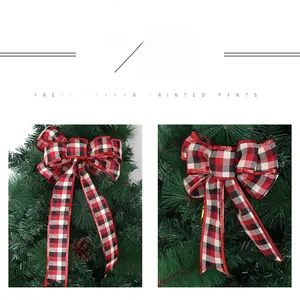 Detail of red and black plaid Christmas bows with glitter edges on green pine branches
