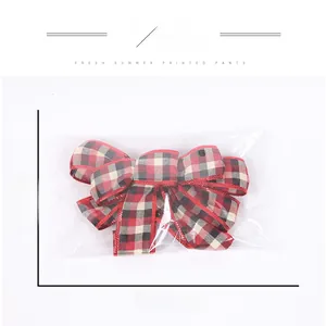 Detail showing red and black plaid Christmas bow dimensions in transparent plastic packaging