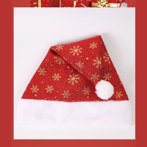 Dettaglio cappello natalizio rosso con fiocchi d'oro e bordo in peluche bianco