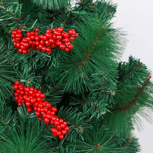 Dettaglio macro di bacche di Natale rosse lucide con decoro di aghi di pino verde