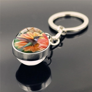 Detailed view of silver hummingbird keychain with double-sided crystal glass ball