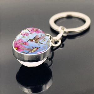 Hummingbird glass ball keychain with pink flowers on a polished silver metal ring