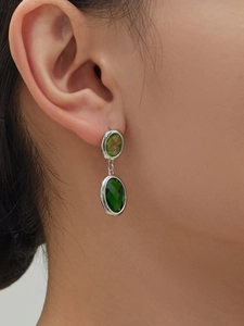 Close-up of elegant double oval green gemstones on 18k gold plated stainless steel earrings