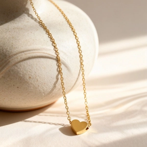 Polished 18k gold heart pendant necklace for women in warm sunlight and shadow scene