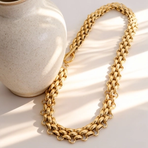 Golden chunky chain necklace with OT clasp closure in a warm aesthetic sunlight setting