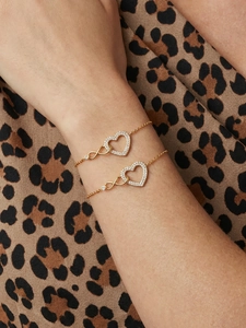 Gros plan d'un ensemble de bracelets cœur et infini dorés avec pavé de zircons cubiques