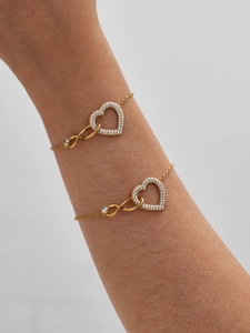 Détail de deux bracelets plaqués or 18 carats avec cœurs, symboles infini et cristaux