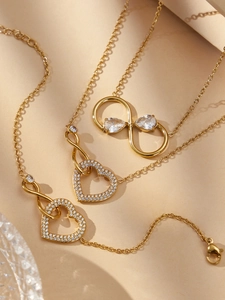 Détail de pendentifs cœur et infini plaqués or 18 carats avec cristaux pavés