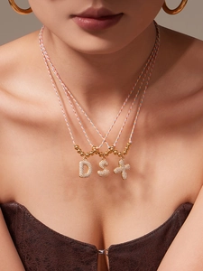 Macro view of colorful braided rope necklaces with zircon micro-pave letter pendants D and S