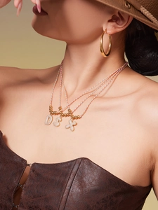 Close-up of zircon-encrusted capital letter pendants on colorful cord necklaces