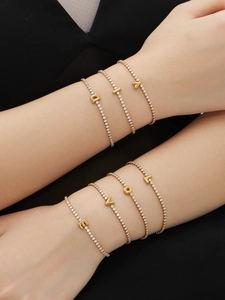 Close-up of 18k gold plated bracelets with zircon letter charms D I A and L O V E