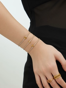 Close-up of 18k gold plated tennis bracelets with sparkling zircon initial pendants