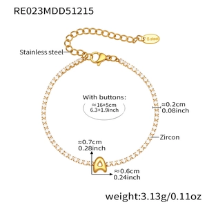 Detail of gold zircon tennis bracelet with a dangling letter A pendant and lobster clasp