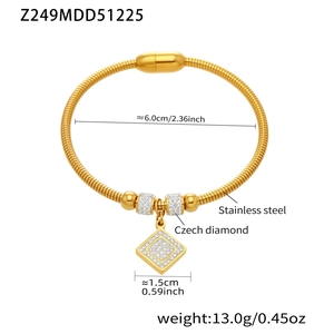 Detalle de brazalete de acero chapado en oro 18k con colgante CZ y cierre magnético