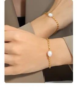 Gros plan d'un bracelet en chaîne dorée avec une perle d'eau douce au poignet