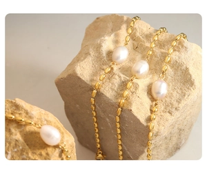Détail macro du bracelet baroque avec perles dorées et perles d'eau douce blanches
