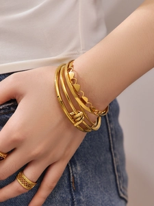 Detailed view of 18k gold plated stainless steel hollow heart bracelets on a model's wrist