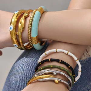 Set di bracciali bohémien con occhio smaltato in finitura oro indossati sul polso