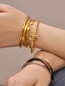 Detail of stacked stainless steel heart bangles and barbed wire design on wrist