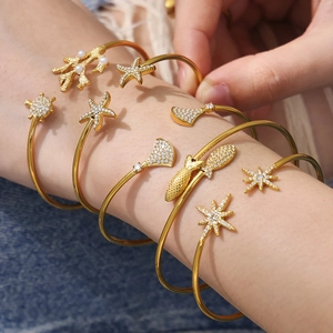 Ensemble de bracelets dorés thème océan avec étoile de mer et tortue sur fond denim
