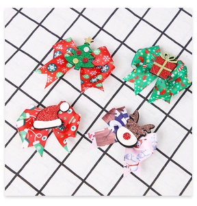 Detailed view of 4-piece Christmas bow hair clips with sequin reindeer and tree motifs