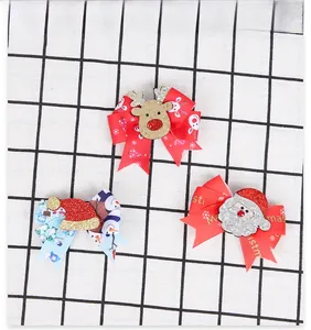 Detailed view of three Christmas bow clips featuring reindeer, snowman, and Santa designs