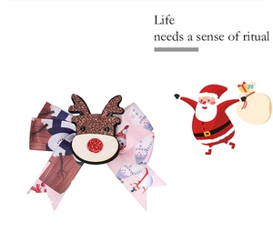 Detail of Christmas bow hair clip with reindeer charm and snowy festive patterns