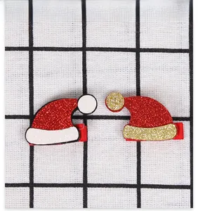Close-up of glittery Santa hat hair clips for kids in festive red and gold colors