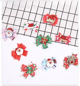 Detail view of 8 handmade Christmas bow hair clips with glitter Santa and reindeer patterns