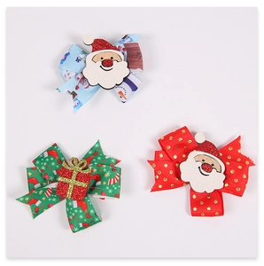 Close-up of three festive Christmas hair clips featuring snowman and Santa patterns