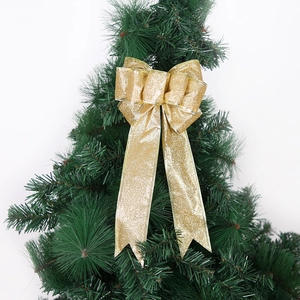 Große goldene Glitzerschleife an einem grünen Tannenbaum für Weihnachtsdekorationen