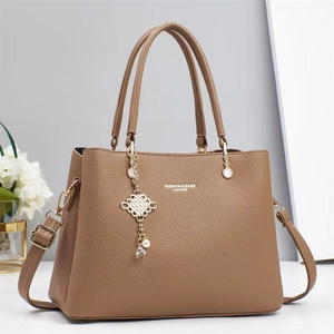 Brown litchi grain PU leather handbag with dual handles and a decorative tassel pendant