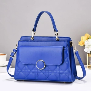 Close-up of quilted pattern and gold metal clasp on vibrant blue shoulder bag