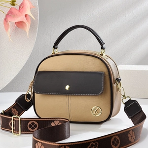 Close-up of khaki pebbled leather bag with golden K logo and floral patterned strap