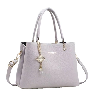 Elegante lavendelfarbene Lederhandtasche mit Perlenanhänger und goldener Hardware