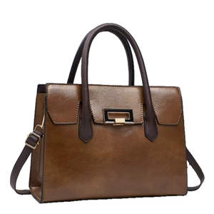 Retro brown leather tote bag with contrast handles and gold hardware lock on white background