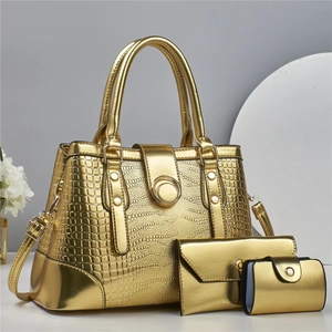 Détail d'un ensemble de sacs à main dorés avec texture lézard et boucles métalliques dorées