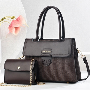 Detailed view of dark brown textured leather tote and mini chain bag with gold hardware