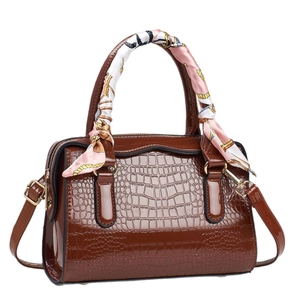 Brown faux leather handbag with crocodile pattern and silk scarf on top handle