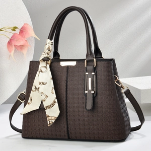 Detailed view of dark brown checkered handbag featuring a decorative silk scarf and gold hardware