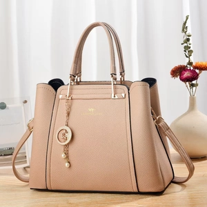 Sac cabas beige élégant avec pendentif étoile sur table en bois devant rideaux blancs