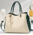 Détail du sac à main bicolore avec pendentif cœur et boucles métalliques dorées