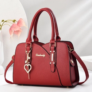 Rote Henkeltasche aus Leder mit Herzanhänger und goldenen Details für modebewusste Damen