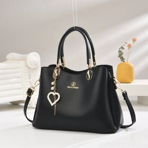 Sac à main noir élégant avec surpiqûres, pendentif cœur doré et bandoulière