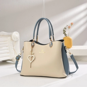 Sac à main bicolore chic en crème et bleu avec détails dorés et pendentif cœur