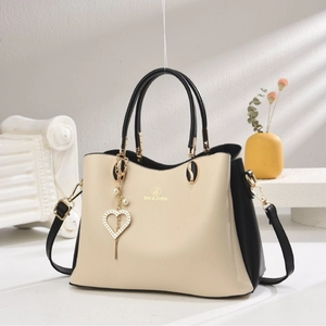Sac à main chic bicolore beige et noir avec pendentif en perle en forme de cœur