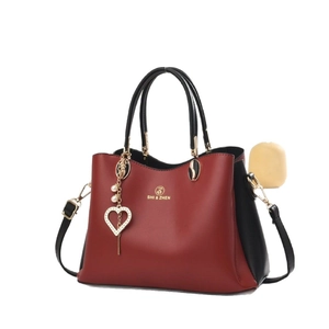 Sac à main chic bicolore rouge et noir avec breloque perle en cœur et finitions dorées