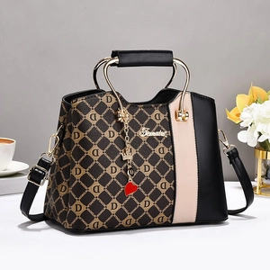 Chic color-block monogram handbag with golden metal handle and luxury heart charm accessory