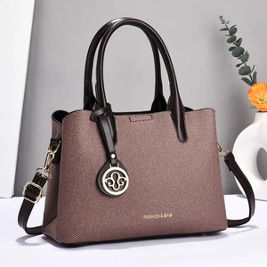 Détails du sac cabas marron tissé avec ferrures dorées et poignées en cuir élégantes